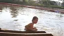 Seorang anak berenang di Kanal Banjir Barat, Jakarta, Jumat (23/3). Mahalnya biaya sewa kolam renang menyebabkan anak-anak berenang tidak pada tempatnya. (Liputan6.com/Immanuel Antonius)