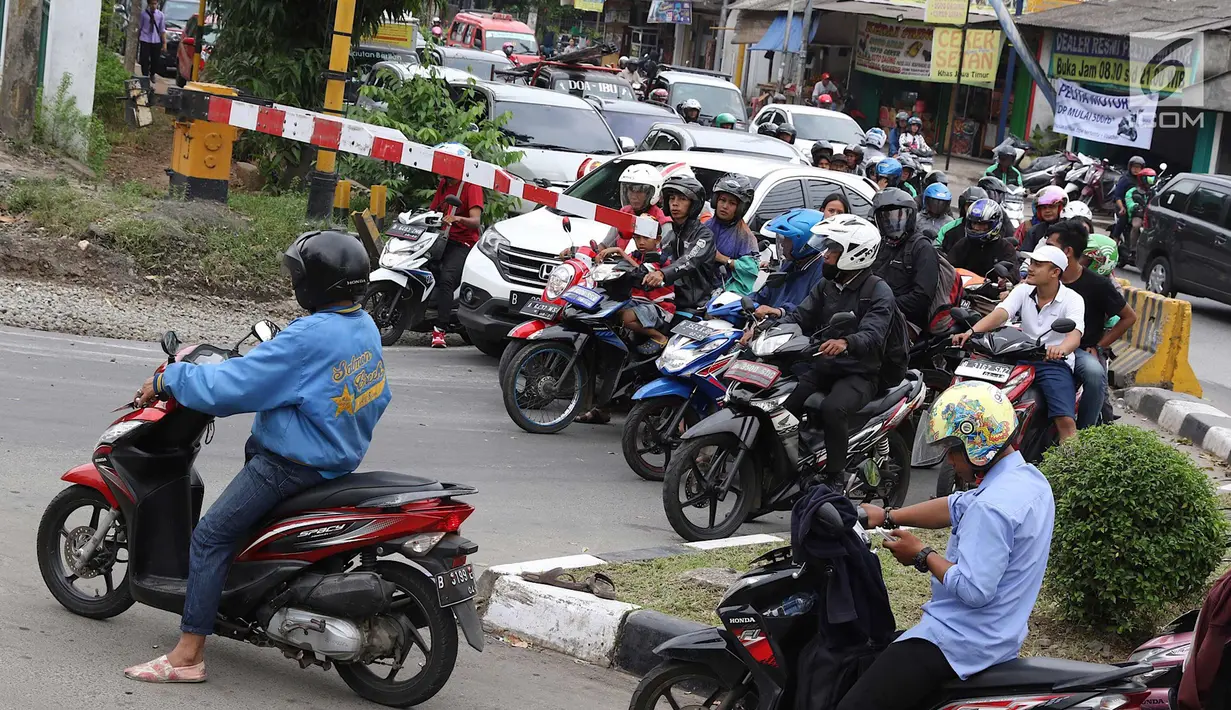 Kendaraan menunggu di perlintasan kereta api di Lenteng Agung, Jakarta, Selasa (13/3). Untuk mengurai kemacetan imbas antrian kendaraan berputar balik di pintu kereta IISIP, Pemprov DKI berencana membangun flyover U-Turn. (Liputan6.com/Immanuel Antonius)