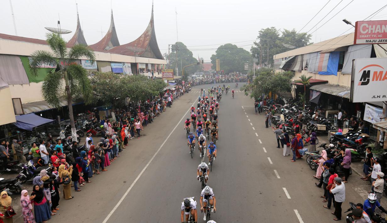 Para pebalap sedang melewati sebuah pasar di kota Payakumbuh dalam Etape 5 Tour de Singkarak 2015, Rabu (7/10/2015). (Bola.com/Arief Bagus)