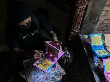 Perajin menyelesaikan pembuatan rekal/lekar untuk meletakkan Al-Quran di Gallery Cemolex, Depok, Jawa Barat, Kamis (22/4/2021). Saat bulan Ramadhan permintaan rekal/lekar meningkat dari 50 sampai 200 buah yang dijual dari harga 50 ribu sampai 100 ribu. (Liputan6.com/Johan Tallo)