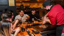 Pengunjung menikmati hidangan teppanyaki Jepang di Chinatown, Melbourne, Australia, Jumat (22/10/2021). Lima juta warga Melbourne kini akhirnya bisa keluar rumah lagi. (William WEST/AFP)