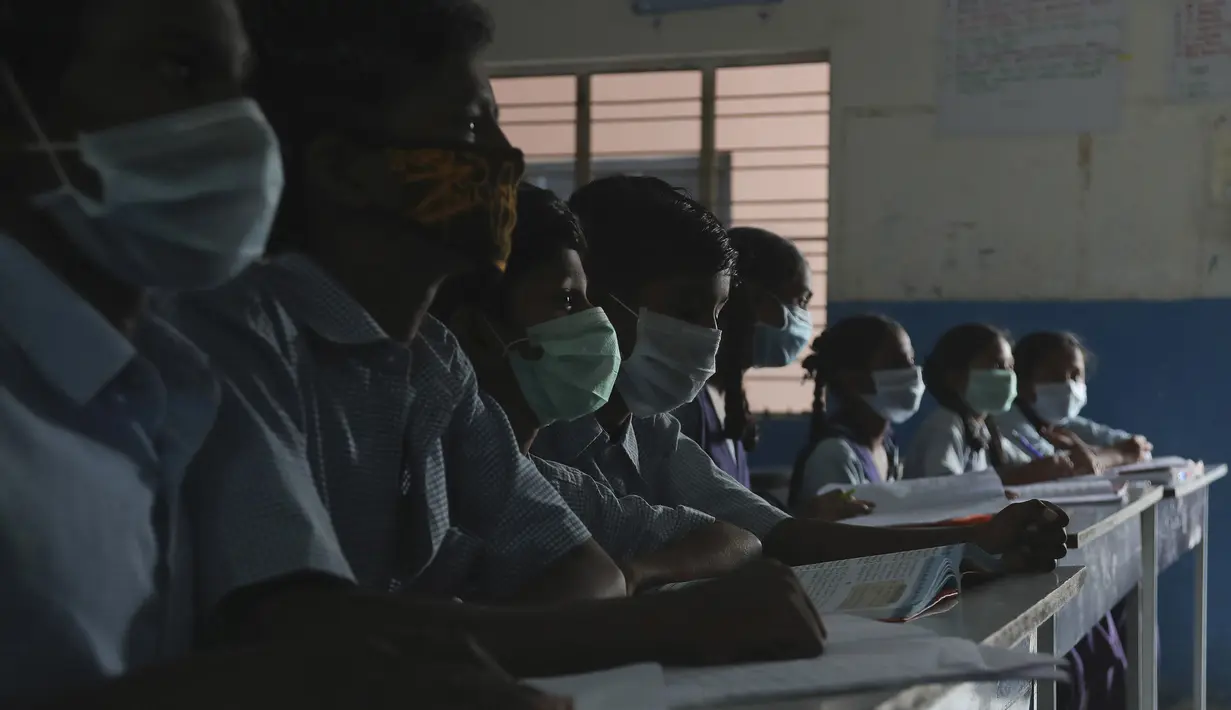 Sejumlah siswa mengenakan masker saat prose belajar mengajar di sebuah sekolah pemerintah di Hyderabad, India, Rabu (4/3/2020). India mengonfirmasi 30 kasus corona. Di seluruh dunia, ada 97.885 kasus corona. (AP Photo/Mahesh Kumar A.)