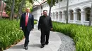 Pemandangan saat Presiden AS Donald Trump (kiri) dan Pemimpin Korea Utara Kim Jong-un berjalan di taman Hotel Capella, Pulau Sentosa, Singapura, Selasa (12/6). Kegiatan ini dilakukan saat istirahat pembicaraan antara AS-Korut. (Anthony Wallace/Pool/AFP)