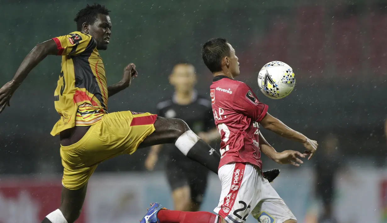 Bek Bali United, Dias Angga, berebut bola dengan pemain Mitra Kukar, Patrick Ochan, pada laga Piala Presiden 2019 di Stadion Patriot, Jawa Barat, Minggu (3/3). Bali United menang 3-0 atas Mitra Kukar. (Bola.com/M Iqbal Ichsan)