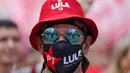 Seorang pendukung mantan presiden Brasil (2003-2010) dan calon presiden dari Partai Buruh (PT) berhaluan kiri, Luiz Inacio Lula da Silva, menghadiri rapat umum kampanye di Sao Mateus, Negara Bagian Sao Paulo, Brasil, Senin (17/10/2022). Lula da Silva dan presiden Jair Bolsonaro akan menghadapi putaran kedua pemilihan presiden pada 30 Oktober, dengan ekspektasi persaingan ketat mendorong kedua belah pihak untuk mengintensifkan kampanye menjelang pemilihan. (Miguel SCHINCARIOL / AFP)