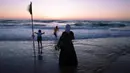 Orang Arab Israel menikmati laut Mediterania selama liburan Idul Fitri, di Tel Aviv, Israel (25/5/2020). Idul Fitri menandai akhir bulan suci Ramadhan, perayaan tiga hari yang biasanya menggembirakan telah berkurang secara signifikan karena pandemi coronavirus.  (AP Photo/Oded Balilty)