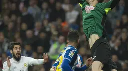 Kiper Espanyol, Giedrius Arlauskis, menepis bola sundulan pemain Real Madrid pada laga La Liga. Sementara bagi Espanyol hasil ini membuat mereka kian terpuruk di posisi ke-15. (AFP/Curto De La Torre)