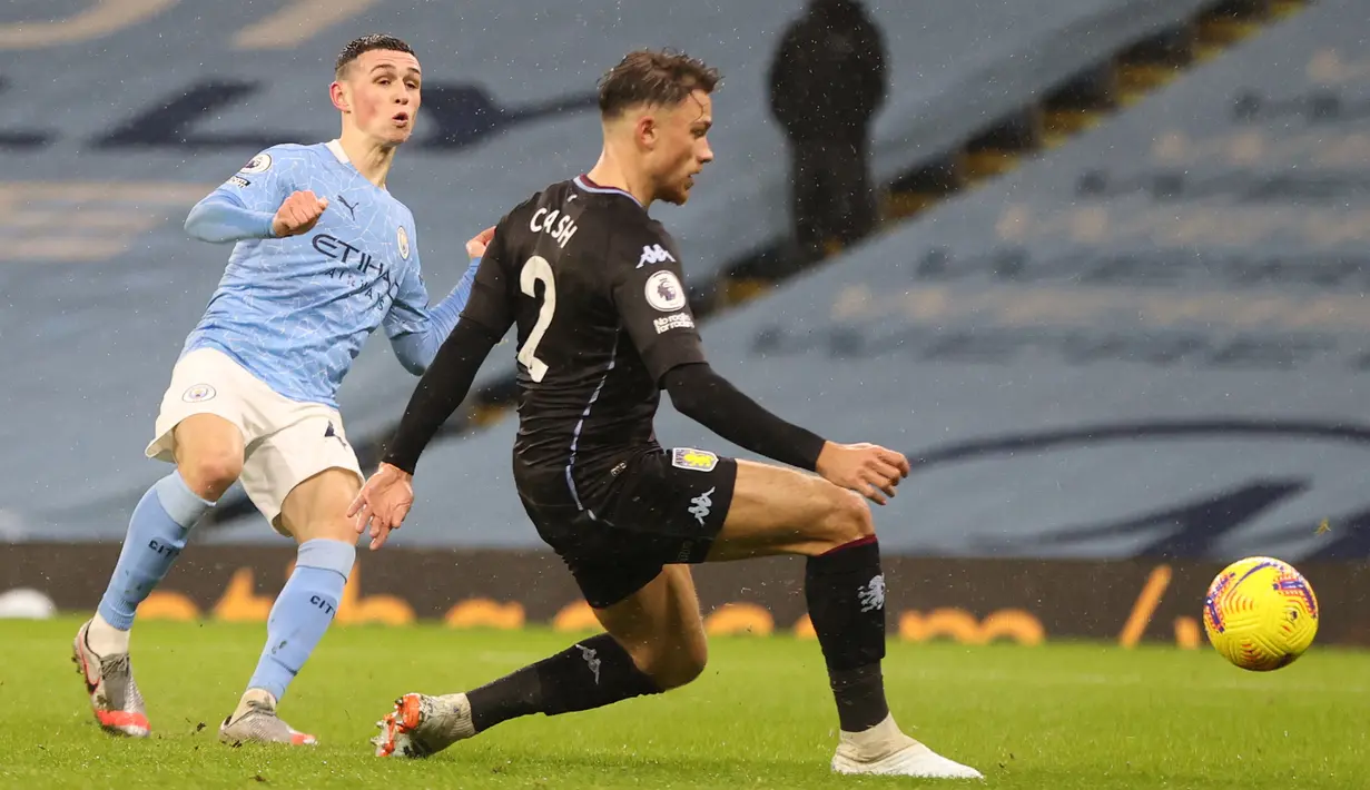 Gelandang Manchester City, Phil Foden, melepaskan tendangan saat menghadapi Aston Villa pada laga lanjutan Liga Inggris di Etihad Stadium, Kamis (21/1/2021) dini hari WIB. Manchester City menang 2-0 atas Aston Villa. (AFP/Clive Brunskill/pool)