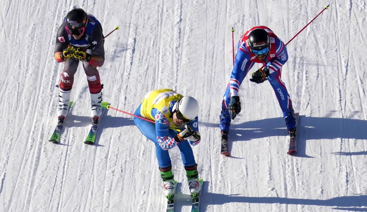 Sergey Ridzick dari Rusia (tengah) melewati garis finish di depan Brady Leman dari Kanada dan Bastien Midol dari Prancis pada nomor lintas ski putra selama acara uji coba Olimpiade Musim Dingin 2022 di Genting Resort Secret Garden di Zhangjiakou, China, Sabtu (27/11/2021). (AP Photo/Mark Schiefelbei