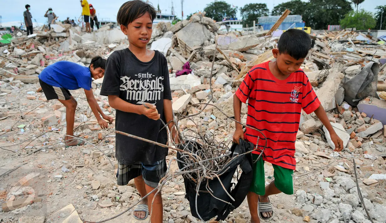 Dua orang anak membawa sisa-sisa besi dari reruntuhan bangunan yang dirobohkan di kawasan Pasar Ikan, Penjaringan, Jakarta, Selasa (12/4). Selain warga, sejumlah pemulung besi berhambur untuk menjarah besi dari bekas bangunan (Liputan6.com/Yoppy Renato)