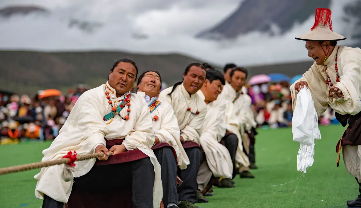 Para kontestan mengikuti kompetisi tarik tambang di Wilayah Damxung, Daerah Otonom Tibet, China, 10 Agustus 2020. Dengan pakaian tradisional, para penggembala dari sejumlah desa di Wilayah Damxung berpartisipasi dalam permainan tradisional itu. (Xinhua/Purbu Zhaxi)