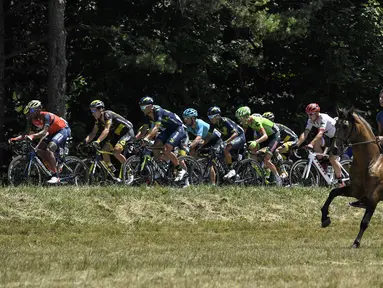 Seorang pengendara kuda mengiringi pebalap Tour de France pada etape ke-16 dengan jarak 165 km dari Le Puy-en-Velay dan Romans-sur-Isere, (18/7/2017).  (AFP/Lionel Bonaventure)