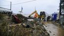 Pekerja mencoba membersihkan area setelah badai petir hebat, di desa Agia Pelagia, di pulau Kreta, Yunani, Sabtu (15/10/2022). Dilaporkan setidaknya satu orang tewas dan lainnya hilang setelah banjir bandang yang parah. (AP Photo/Harry Nakos)