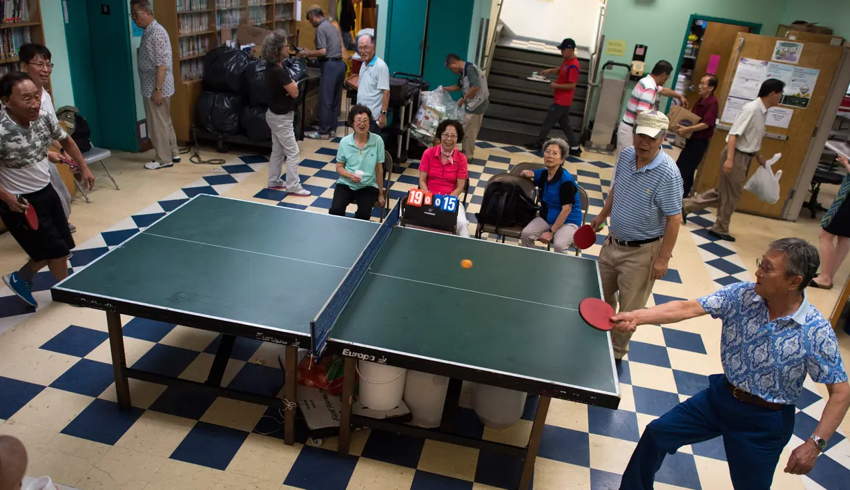 Warga bermain pingpong di pusat Layanan Komunitas Korea di New York, AS (10/8). Kebanyakan dari mereka berada di wilayah kecil Presiden Donald Trump di Queens. (AFP Photo/Don Emmert/To Go With AFP STORY by Jennie Matthew, NKorea-US-nuclear-diaspora)