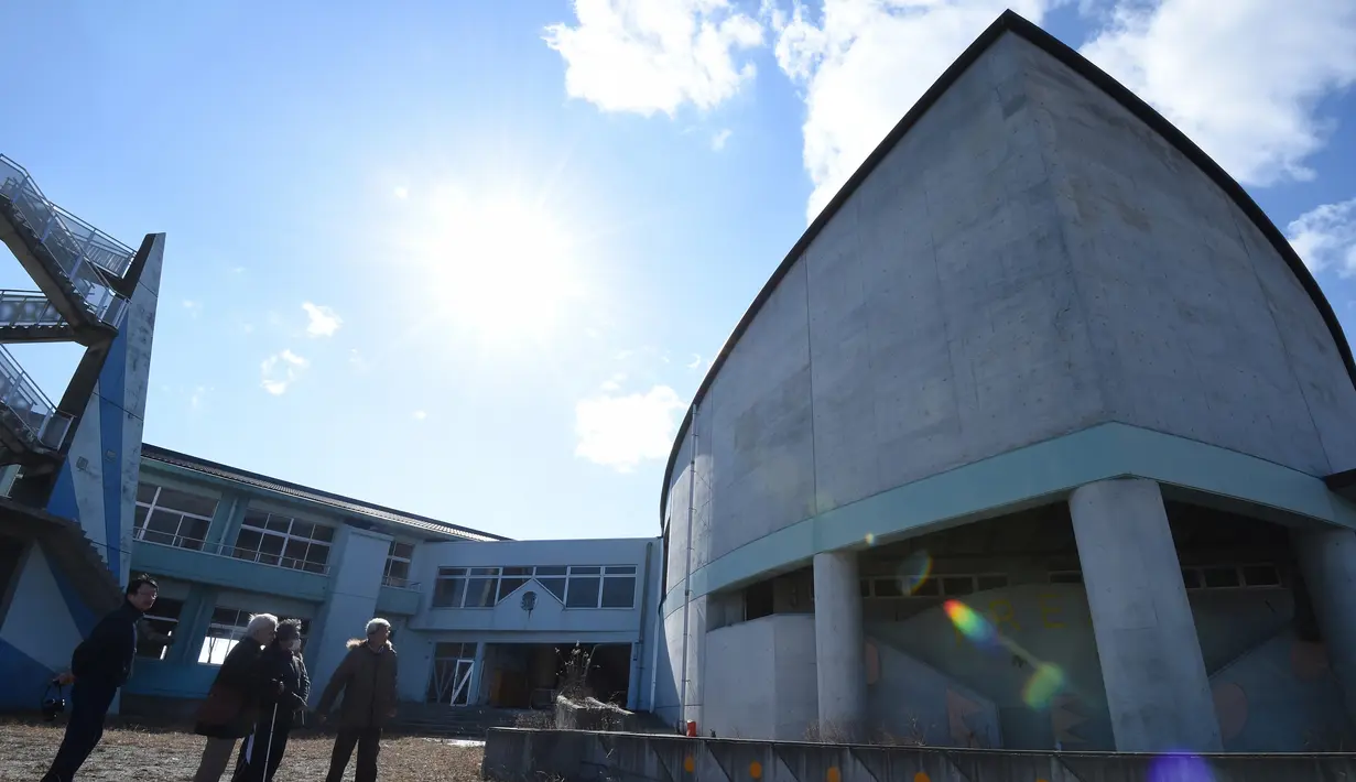 Wisatawan melihat Sekolah Dasar Ukedo di Namie, Prefektur Fukushima, 11 Februari 2016. Lima tahun pasca bencana nuklir yang dipicu oleh gempa dan tsunami Jepang, semakin banyak wisatawan yang bergabung dengan tur Fukushima. (AFP PHOTO/Toru Yamanaka)