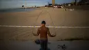 Seorang pria berolahraga di pinggir pantai yang ditutup di Barcelona, Spanyol, Sabtu (2/5/2020). Pemerintah Spanyol berharap aktivitas di luar rumah dapat meningkatkan kebugaran warga. (AP Photo/Emilio Morenatti)