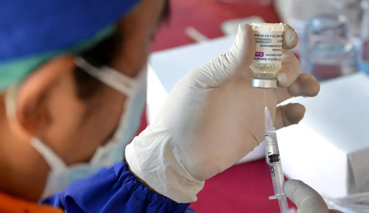 Seorang petugas kesehatan menyiapkan dosis vaksin virus corona COVID-19 AstraZeneca di Denpasar, Bali, Sabtu (26/6/2021). Ratusan warga terlihat antusias mengikuti vaksinasi massal tersebut. (SONY TUMBELAKA/AFP)