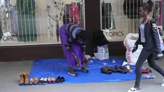 Pedagang kaki lima memajang sepatu baru dan bekas dengan harga murah di luar pintu masuk toko pakaian di jalanan Harare, dalam foto Senin, 22 Mei 2023 ini. (AP Photo/Tsvangirayi Mukwazhi)