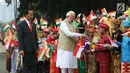 Perdana Menteri (PM) India, Narendra Modi didampingi Presiden Joko Widodo (Jokowi) bersalaman dengan murid Sekolah Dasar berpakaian adat Indonesia dalam upacara penyambutan di Istana Merdeka, Jakarta, Rabu (30/5). (Liputan6.com/Angga Yuniar)