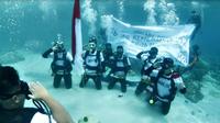 PT Asuransi Kredit Indonesia (Askrindo) merayakan HUT Kemerdekaan Republik Indonesia ke-76 dengan pengibaran bendera Merah Putih di bawah laut Pantai wisata Jikomalamo, Ternate, Maluku Utara. (Dok. Askrindo)