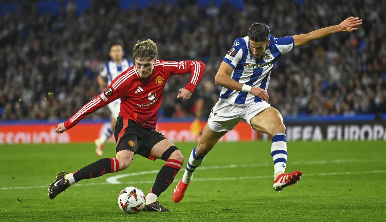 Pemain Manchester United, Alejandro Garnacho (kiri) berebut bola dengan pemain Real Sociedad, Nayef Aguerd dalam laga leg 1 babak 16 besar Liga Europa 2024/2025 di Anoeta Stadium, San Sebastian, Spanyol, Jumat (07/03/2025) dini hari WIB. (AP Photo/Miguel Oses)