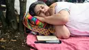 Seorang wanita Kolombia tidur saat berparade dalam merayakan Hari Kemalasan Sedunia di Itagui, dekat Medellin, Minggu (19/8). Perayaan hari relaksasi selama seharian itu telah digelar setiap tahun sejak 1985 di kota kecil tersebut. (AFP/JOAQUIN SARMIENTO)