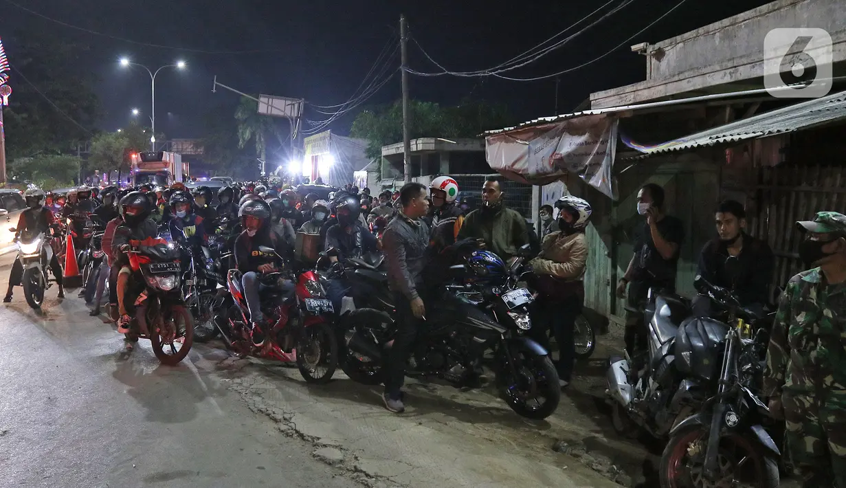 Pemudik menghentikan motornya di posko penyekatan mudik di Kedungwaringin, Kabupaten Bekasi, Jawa Barat, Minggu (9/5/2021). H-3 jelang Idul Fitri, petugas gabungan TNI, Polri, Dishub, dan Satpol PP memperketat penjagaan pemudik di perbatasan Kabupaten Bekasi-Karawang. (Liputan6.com/Herman Zakharia)