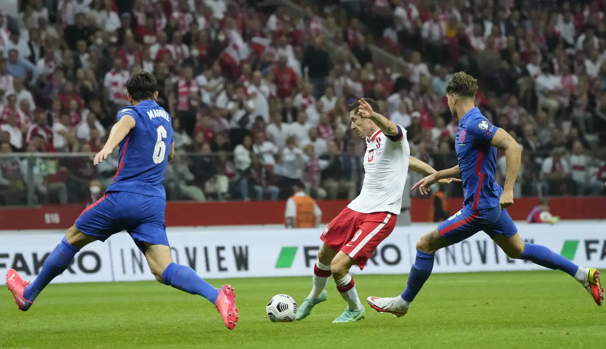 Bek Inggris, Harry Maguire berusaha memblok bola tendangan Penyerang Polandia, Robert Lewandowski  pada kualifikasi grup I Piala Dunia 2022 di stadion Narodowy di Warsawa (9/9/2021).  Polandia berada di peringkat kedua dengan 11 poin dari enam kali pertandingan. (AP Photo/Czarek Sokolowski)