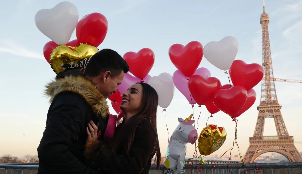 Gerson asal Honduras melamar pasangannya Andry pada Hari Valentine ketika berdiri di Trocadero Plaza dekat Menara Eiffel di Paris, Prancis (14/2). (AFP Photo/Ludovic Marin)