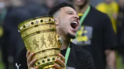 Gelandang Dortmund, Jadon Sancho memegang trofi setelah memenangkan pertandingan melawan RB Leipzig pada divisi satu Bundesliga di Berlin pada 13 Mei 2021. Kabar resminya Jadon Sancho ke Manchester United diumumkan melalui akun Twitter resmi klub. (AFP/Pool/John Macdougall)