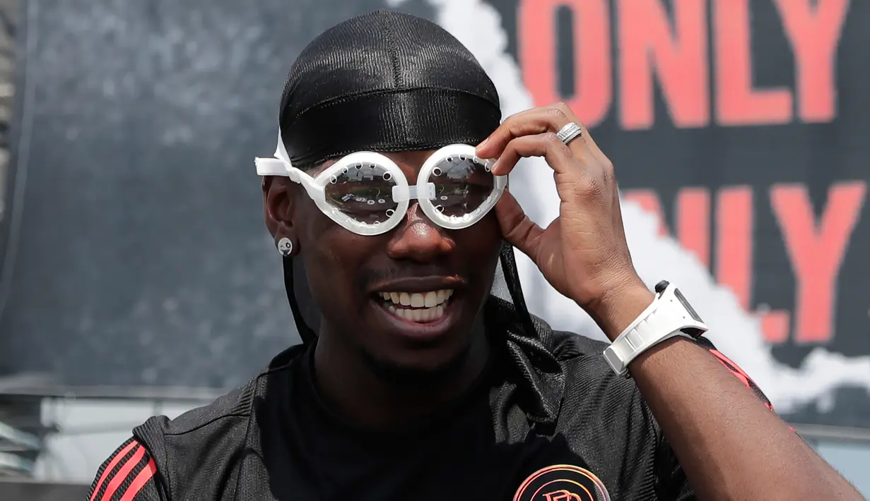 Gelandang Manchester United asal Prancis, Paul Pogba merapikan kaca mata yang diberikan fans selama pertemuan dengan para penggemarnya pada juma pers di Seoul, Korea Selatan, Kamis (13/6/2019). Paul Pogba berada di Seoul sebagai bagian dari tur Asia-nya. (AP Photo/Lee Jin-man)