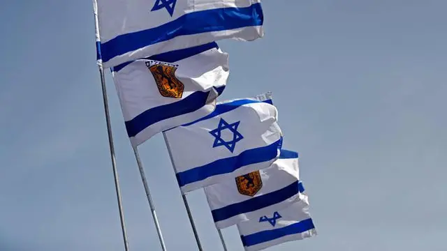 Bendera Israel berkibar di dekat Gerbang Jaffa di Kota Tua Yerusalem (20/3). Gerbang Jaffa adalah sebuah portal yang dibuat dari batu yang berada dalam deret tembok bersejarah Kota Lama Yerusalem. (AFP Photo/Thomas Coex)