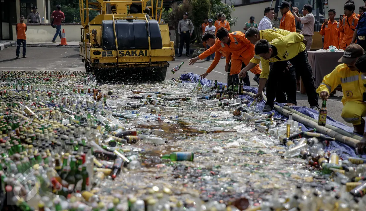 Petugas dibantu dengan alat berat buldoser memusnahkan minuman keras di Polres Jakarta Utara, Selasa (16/5). Pemusnahan diharapkan muncul situasi keamanan dan ketertiban masyarakat (kamtibmas) yang kondusif. (Liputan6.com/Faizal Fanani)