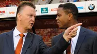 Asisten pelatih Timnas Belanda, Patrick Kluivert (kanan) berbicang dengan pelatih kepala Louis van Gaal saat laga persahabatan melawan Belgia di Brussels, Belgia, 15 Agustus 2012. (AFP/John Thys)