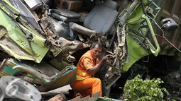 Petugas mengevakuasi truk ringsek yang menabrak tiang rambu petunjuk arah di Jalan Tol Jakarta-Tangerang, Jakarta, Senin (5/9). Truk bernomor polisi B 935 IC menabrak tiang rambu lalu lintas di kilometer 6,5. (Liputan6.com/Yoppy Renato)