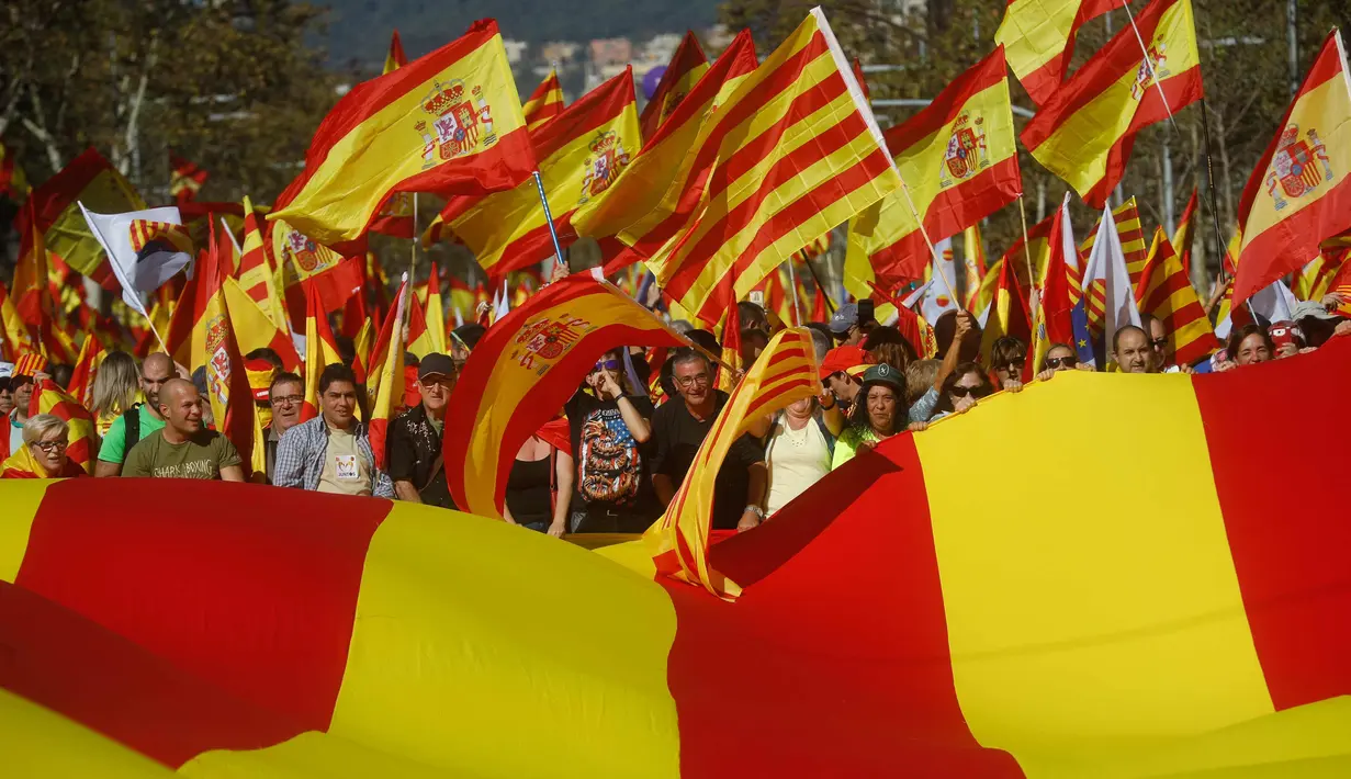 Demonstran mengibarkan bendera Spanyol dan Catalonia selama demonstrasi massal melawan deklarasi kemerdekaan Catalonia, di Barcelona, Spanyol, (29/10). Mereka menyerukan persatuan dan menolak deklarasi kemerdekaan Catalan. (AP Photo/Gonzalo Arroyo)