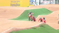 Pembalap BMX putri Indonesia, Amellya Nur Sifa (depan) memimpin sambil melewati rintangan pada lomba balap sepeda nomor BMX putri Asian Games 2022 di Chun'an Jieshou Sports Centre BMX Course, Minggu (1/10/2023) pagi WIB. (PB ISSI/Nick Hanoatubun)