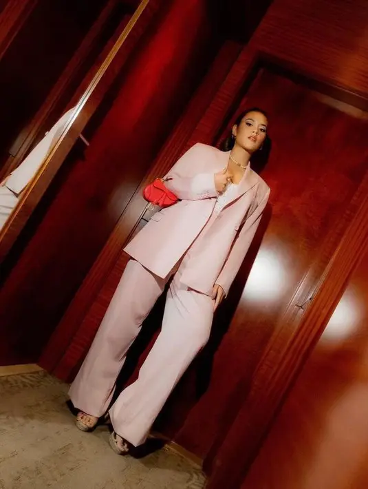 Tampil semi formal saat hadiri press conference, Raisa memadukan one set blazer warna baby pink dengan bandeau putih. Handbag warna merah mencolok pun membuat penampilannya semakin stunning. (Instagram/raisa6690).