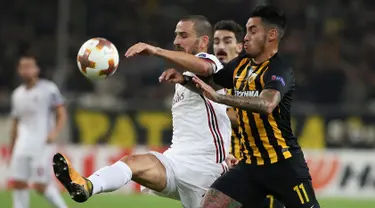 Pemain AC Milan, Leonardo Bonucci berebut bola dengan pemain AEK Athens, Sergio Araujo dalam laga lanjutan Grup D Liga Europa di Stadion Athens Olympic, Jumat (3/11). Tandang ke markas AEK, Milan hanya meraih hasil imbang 0-0. (AP/Petros Giannakouris)