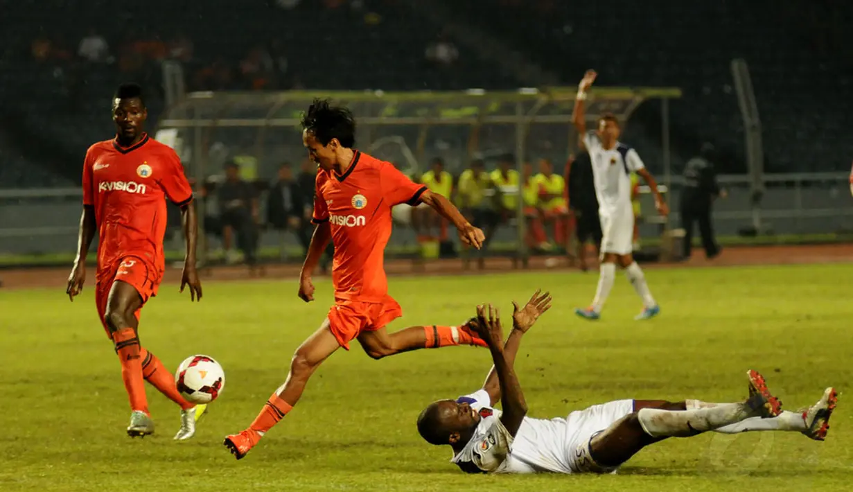 Gelandang Persija, Amarzukih (tengah) melompat menghindari tackling Bezi Frank Eduard (Persik Kediri) saat berlaga di stadion GBK Jakarta, (30/5/2014). (Liputan6.com/Helmi Fithriansyah)