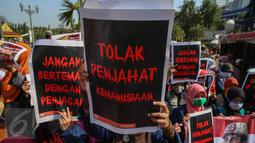 Massa membawa poster saat menggelar aksi di depan Istana Negara, Jakarta, Kamis (3/9/2015). Massa menolak kedatangan Presiden Mesir Abdel Fatah Al Sisi ke Indonesia terkait pelanggaran HAM dan demokrasi di Mesir. (Liputan6.com/Faizal Fanani)
