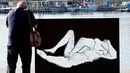 Seorang pria mengabadikan gambar patung erotis karya seniman Antoni Miro yang dipamerkan di pelabuhan Valencia, Spanyol (19/9). (AFP Photo/Jose Jordan)