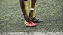 Pemain Mali sedang membenahi tali sepatunya saat bermain melawan Guinea dalam turnamen sepak bola untuk kaum migran dan orang asing bertajuk "Balon Mundial" yang dihelat 6 Juni-5 Juli 2015 di Turin, Italia. (AFP PHOTO/MARCO BERTORELLO)