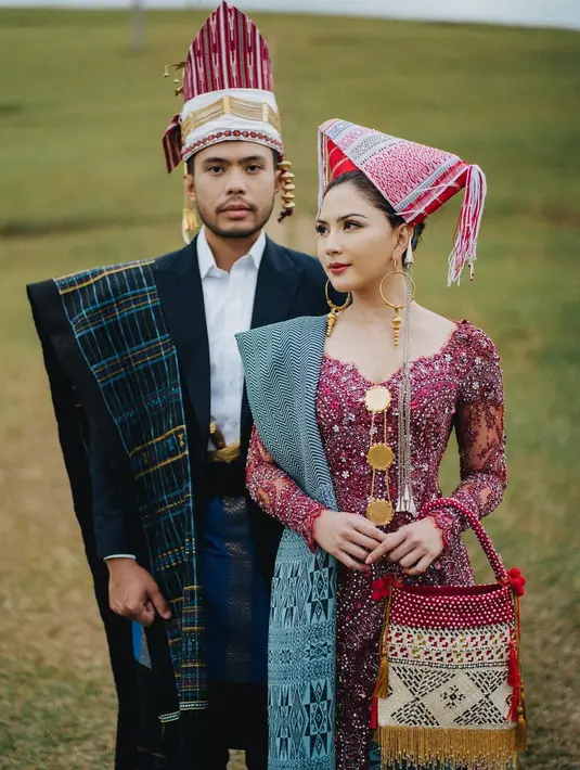 Di momen foto preweddingnya bersama Yakup Hasibuan, Jessica Mila memilih pakaian adat Batak. Ia mengenakan kebaya bernuansa ungu wine penuh payet emas yang kontras, namun mewah, dipadu kain adat berwarna hijau, dengan penutup kepalanya yang serasi. [Foto: Instagram/jscmila]