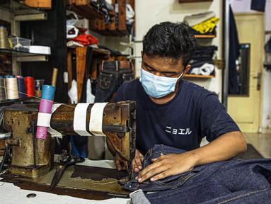 Penjahit menjahit bahan di Nyoel Jeans co, Jakarta, Jumat (22/10/2021). Harga kapas acuan dunia berhasil melesat hingga level tertingginya dalam satu dekade terakhir karena beberapa faktor yang mempengaruhinya. (Liputan6.com/Faizal Fanani)