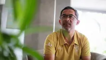 Pelatih kepala Persebaya Surabaya, Aji Santoso saat memberikan keterangan kepada wartawan di Apartemen Puncak Marina Tower 2, Wonocolo, Surabaya, Selasa (11/10/2022). (Bola.com/Bagaskara Lazuardi)