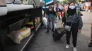 Pemudik menurunkan barang ketika tiba di Terminal bus Kalideres, Jakarta Barat, Senin (17/5/2021). Arus balik pemudik mulai terlihat di sejumlah terminal di Jakarta, salah satunya di Terminal Kalideres. (Liputan6.com/Angga Yuniar)