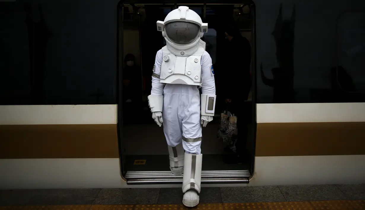 Seorang pria berpakaian astronaut turun dari kereta di stasiun metro saat imelakukan perjalanan sebagai bagian dari kampanye untuk mempromosikan Pameran Luar Angkasa NASA di Istanbul, Turki, pada 4 Desember 2021. Pameran tersebut akan dibuka untuk umum bulan ini. (AP Photo/Emrah Gurel)