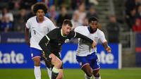Gelandang Australia Connor Metcalfe berebut bola dengan bek Amerika Serikat Mark McKenzie dan Chris Richards di laga uji coba internasional kontra Australia, Commerce City, Colorado, 14 Oktober 2025. (AP Photo/David Zalubowski)