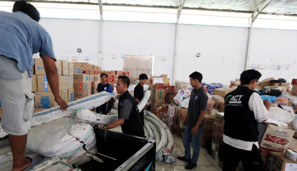 Petugas menurunkan bantuan 4 tenda darurat dan kebutuhan lainnya dari PT Jakarta International Container Terminal (JICT) untuk korban gempa dan tsunami di Palu dan Donggala di Gudang IHC-ACT Parung, Bogor, Jumat (12/10). (Liputan6.com/HO/Arif)